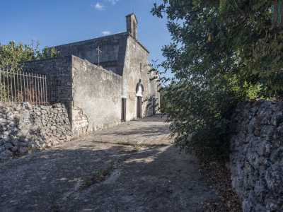 Superato il campanile ci troviamo in una sorta di cortile protetto da un muretto a secco e circondato da ulivi, melograni...
